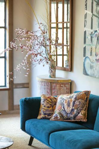 a blue couch in a living room with a vase at AL RU Farm in Sampsons Flat