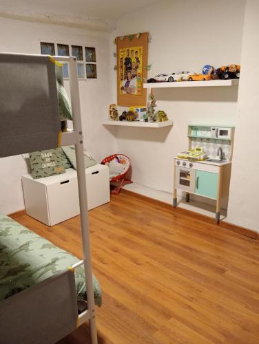 a room with a bunk bed and a play area at Familiar casa en Letux in Letux