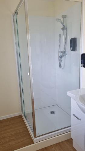 a shower with a glass door in a bathroom at Twin Coast Adventures in Kaikohe