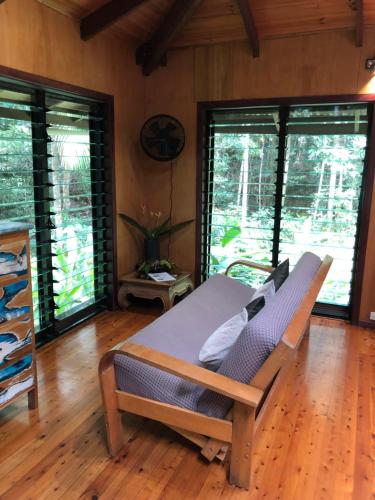 a room with a bench in a room with windows at Wildwood in Cape Tribulation