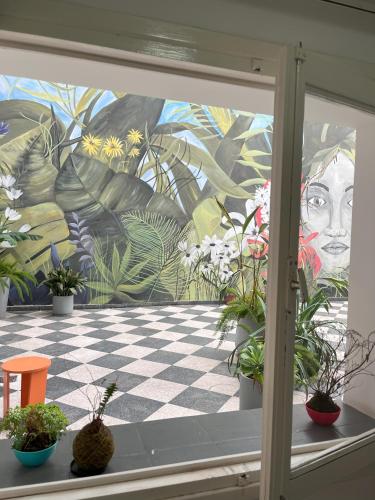 a window with potted plants in front of a mural at Selina Salta in Salta