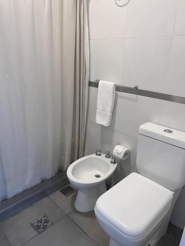 a white bathroom with a toilet and a sink at Selina Salta in Salta