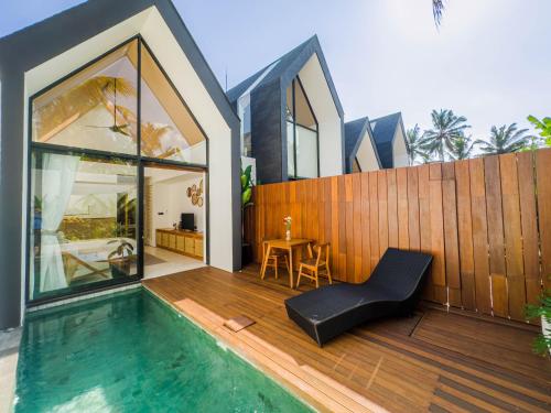 a house with a swimming pool next to a wooden fence at Tannari Villa Ubud in Ubud