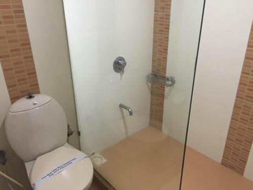een badkamer met een toilet en een glazen douche bij Hotel Platinum Inn in Ahmedabad