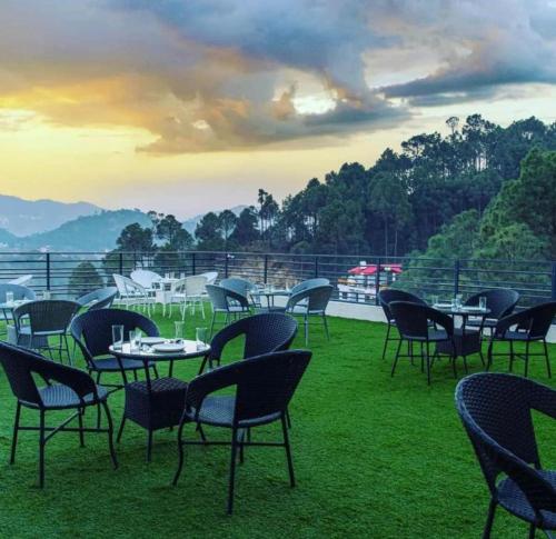 a group of tables and chairs sitting on the grass at Host jatin Corner Cottage kasauli 7o1827o7o3 in Kasauli