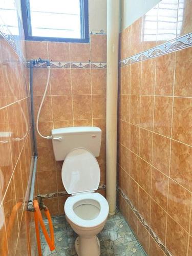 a bathroom with a toilet in a tiled wall at Near Aeon Taiping and Taiping Sentral Mall in Kamunting