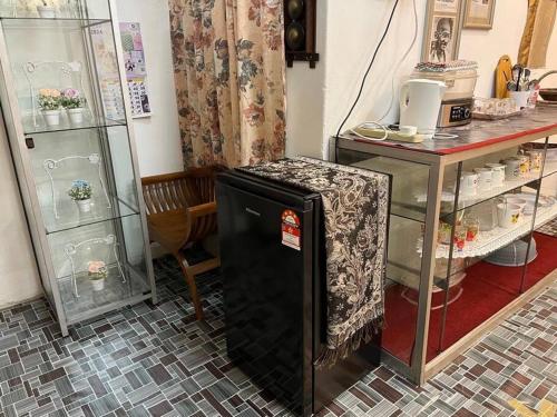a small refrigerator in a room with a table at Near Aeon Taiping and Taiping Sentral Mall in Kamunting