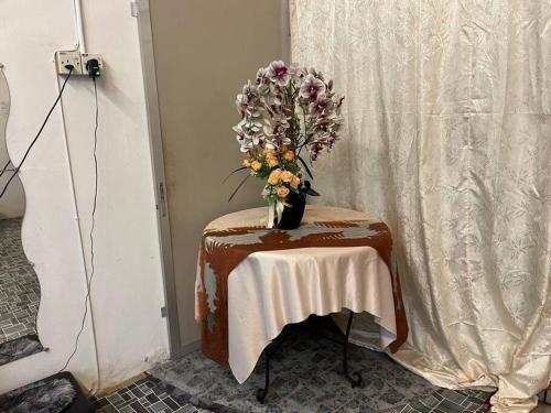 a table with a vase of flowers on it at Near Aeon Taiping and Taiping Sentral Mall in Kamunting