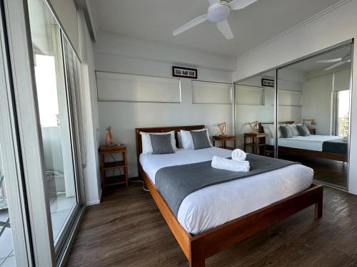 a bedroom with a large bed and a mirror at Story Apartments in Brisbane