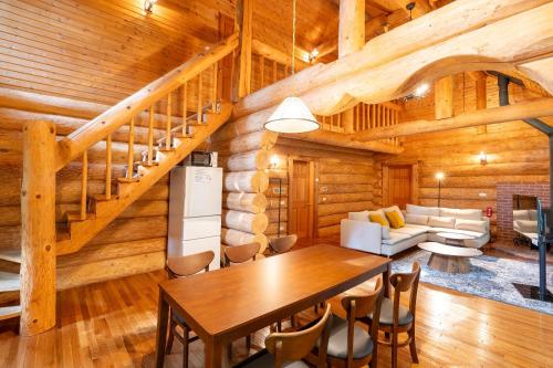 a dining room and living room in a log cabin at S-villa Karuizawa Muguet in Hoshina