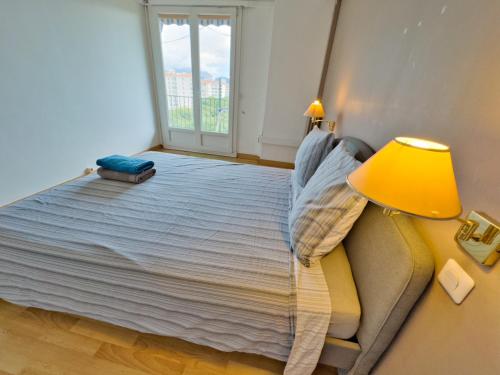 - une chambre avec un lit doté d'une lampe jaune et d'une fenêtre dans l'établissement Vue Incroyable, Lumineux & Calme, à Marseille