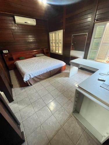 a bedroom with a bed and a desk in a room at Casa de Praia em São Luís in Pimenta