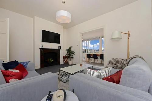a living room with two couches and a fireplace at The Lollyshop Apartment in Battery Point in Hobart