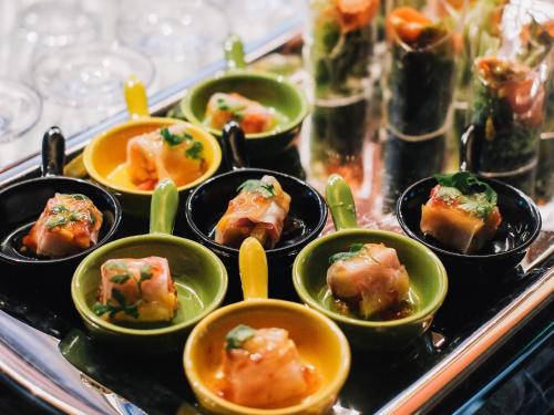 a tray filled with small dishes of food with spoons at Hotel Indigo Guangzhou Haixinsha by IHG - Free Shuttle Bus to Canton Fair Complex during Canton Fair period in Guangzhou