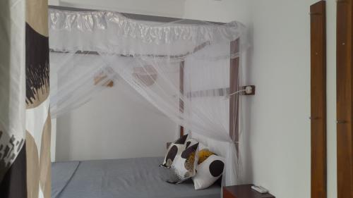 a bedroom with a bed with a white canopy at SriMany in Mirissa