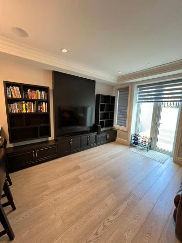 a large living room with a large flat screen tv at Private Rooms in Vancouver West in Vancouver
