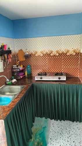 a kitchen with a counter top with a sink at Faridd homestay in Kampung Titi Tampang
