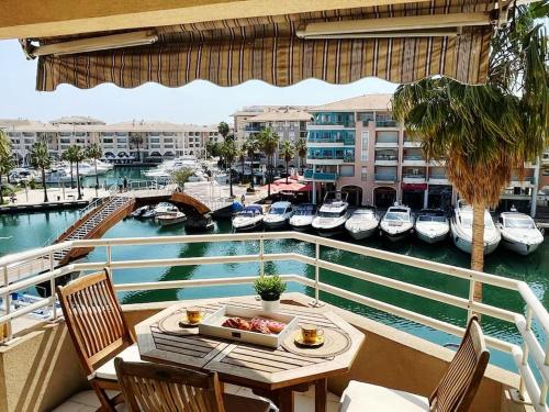 d'un balcon avec une table et des chaises ainsi qu'un port de plaisance. dans l'établissement L Escapade T2 Port Fréjus, à Fréjus