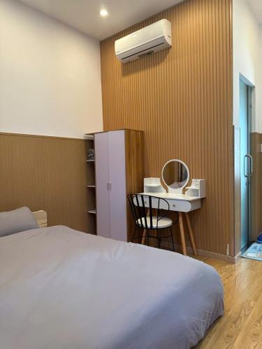 a bedroom with a bed and a table and a sink at Ham Homestay in Vung Tau