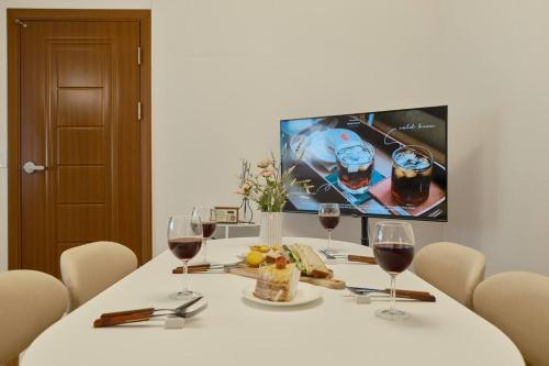 a table with two glasses of wine and food on it at Haru Stay in Seoul