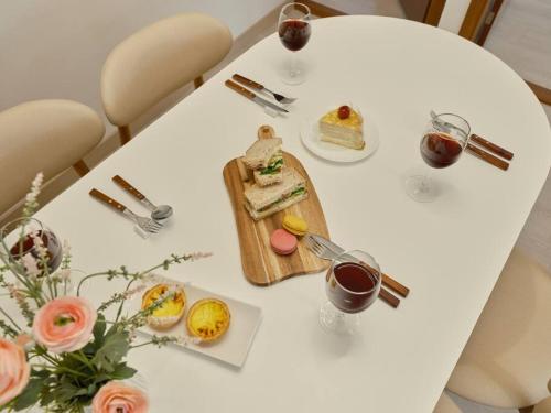 a white table with food and glasses of wine at Haru Stay in Seoul