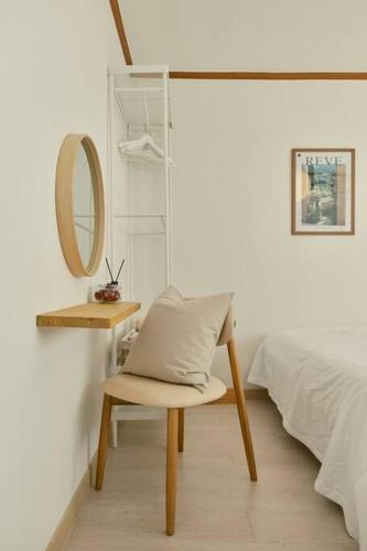 a bedroom with a chair and a mirror and a bed at Haru Stay in Seoul