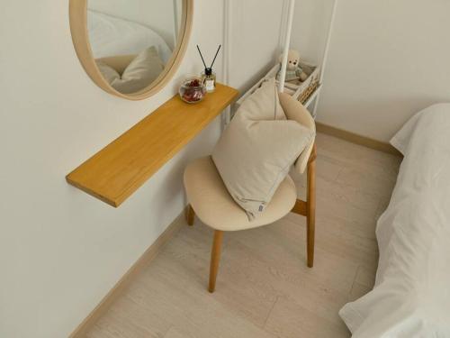 a mirror and a white chair in a bedroom at Haru Stay in Seoul