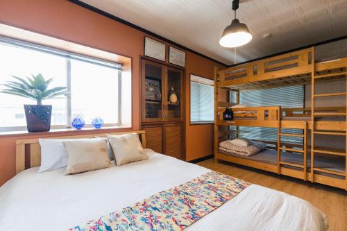 a bedroom with a bed and a bunk bed at 貸別荘TANoSHI-SA- in Jahana