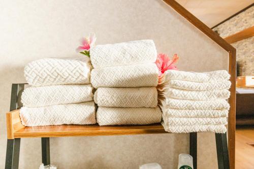 a stack of towels sitting on a shelf at 貸別荘TANoSHI-SA- in Jahana