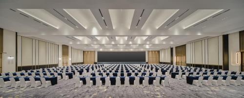 an empty conference room with chairs and a screen at Crowne Plaza Kunshan East by IHG in Kunshan