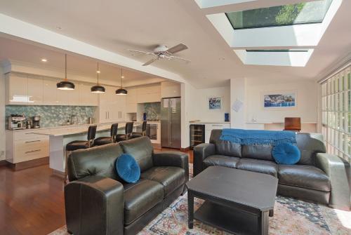 a living room with a couch and a table at Camellia House - Elevator Access, Swimming, and Spa Pools in Nelson