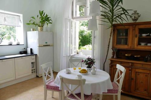 a kitchen with a white table with chairs and a white refrigerator at VILLA GIULIETTA BUDAPEST with GARDEN, FREE PARKING in Budapest