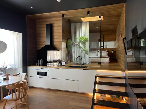 a kitchen with white cabinets and a sink and a table at The Ryokan - Zen in Sydney