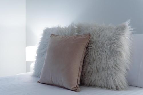 a couple of pillows sitting on a bed at Cosy Riverside Escape with River Views in Inveresk