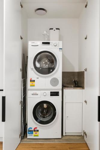 a washing machine and a dryer in a kitchen at Stylish and Modern 2BR w King Bed, Study and Car Park in Carnegie