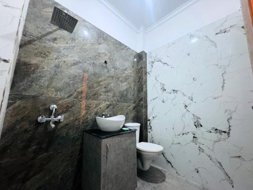 a bathroom with a toilet and a sink at Staybook The Rudveda Resort - Free High Tea near Pool Area in Rāmnagar
