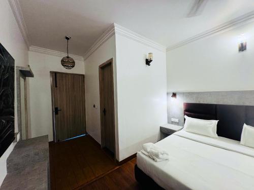 a hotel room with a bed and a door at Staybook The Rudveda Resort - Free High Tea near Pool Area in Rāmnagar