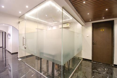 a glass wall in a hallway with a door at FabHotel Olive Suite - Near Airforce get in Pune
