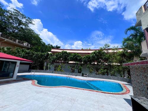 a swimming pool in the middle of a courtyard at Staybook The Rudveda Resort - Free High Tea near Pool Area in Rāmnagar