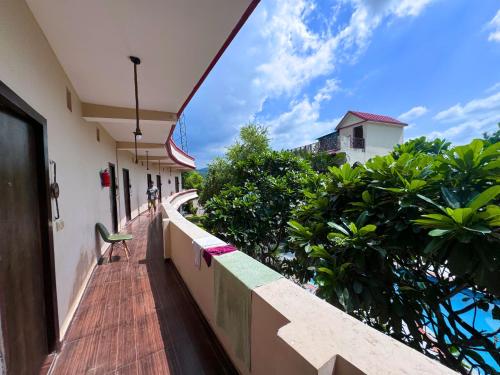 a balcony of a building with a chair on it at Staybook The Rudveda Resort - Free High Tea near Pool Area in Rāmnagar