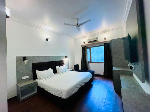 a hotel room with a bed and a tv at Staybook The Rudveda Resort - Free High Tea near Pool Area in Rāmnagar