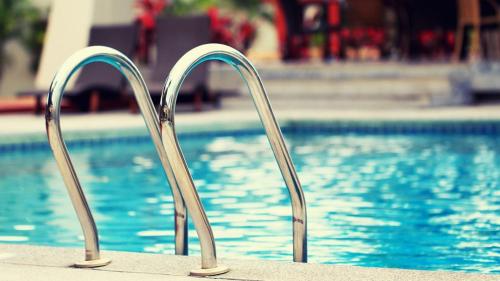 a pair of metal rails next to a swimming pool at Elegance Oasis - Central 3BR Apartment with Balcony and WiFi in Maitama in Abuja