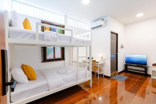 een slaapkamer met witte stapelbedden en een bureau bij Diff Hostel in Bangkok