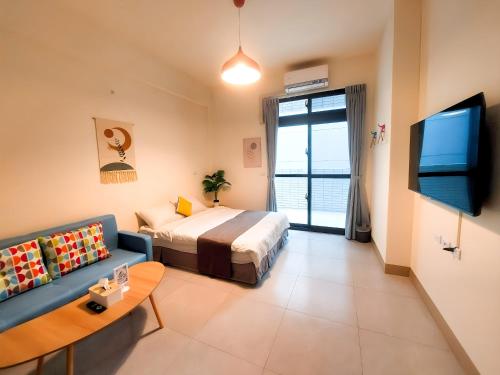 a bedroom with a bed and a tv and a couch at 雀居民宿 in Yuli