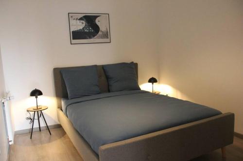 a bed in a room with two lamps and a bed sidx sidx sidx at L'escapade, entièrement rénové, proche centre in Grenoble