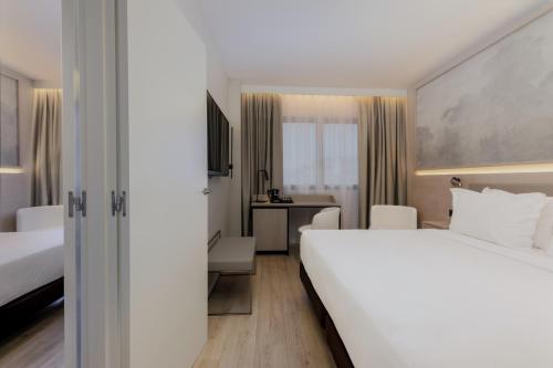 a hotel room with a large bed and a desk at Hotel Vilamarí in Barcelona