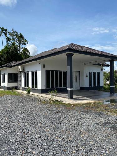 a small white house with a lot of windows at De'Orchard 748 in Kampong Batu Ampat Sanglang