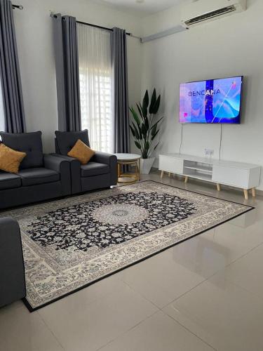 a living room with a couch and a tv at De'Orchard 748 in Kampong Batu Ampat Sanglang