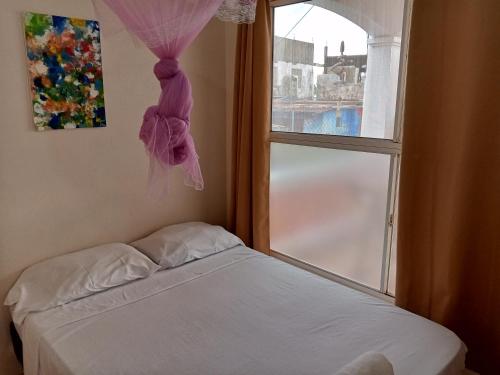 a bedroom with a bed and a window with a bow at Christina's Guest House OFFICIAL in Little Corn Island