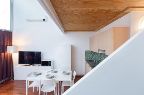 a dining room with a white table and chairs at White and Brown Exclusive Loft With Terrace - Free Parking - M2 station in Milan